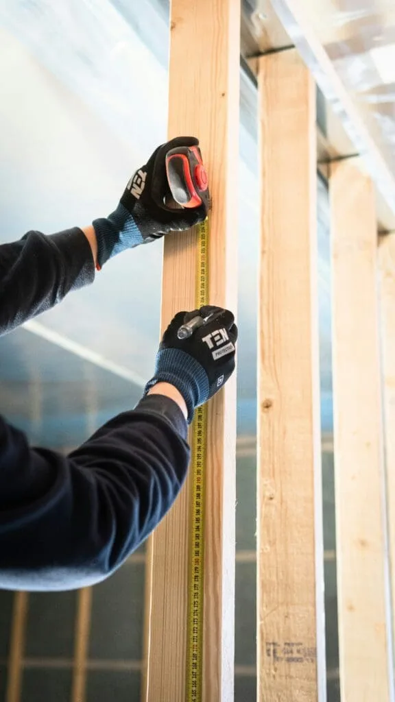 handyman measuring a stud