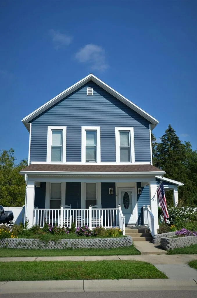 Exterior renovation construction completed with new siding, gutters, and color-matched trim