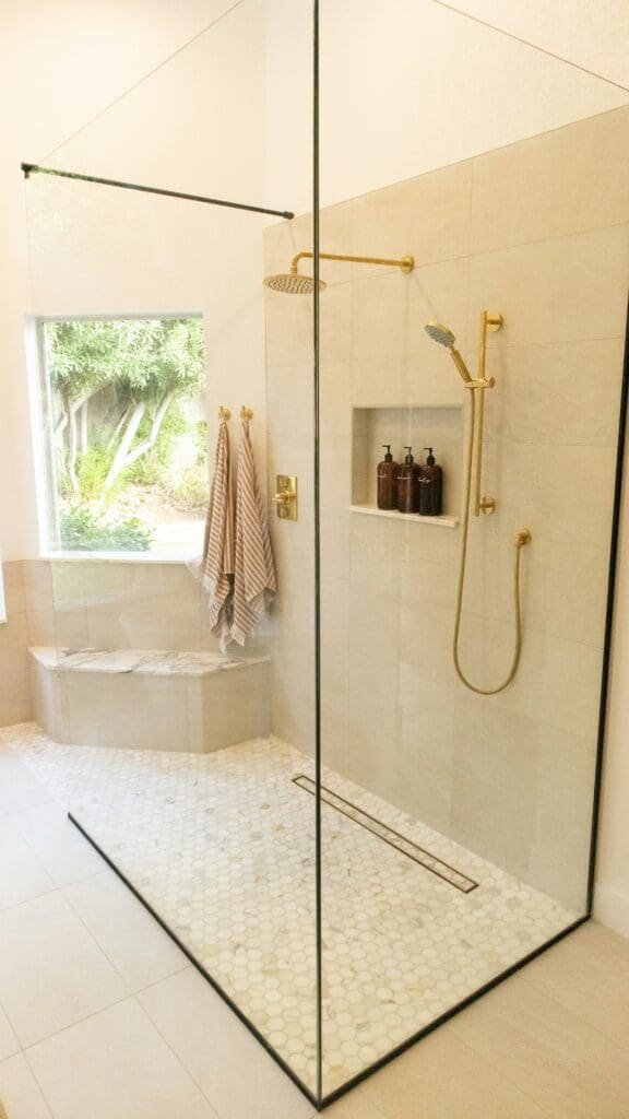 Low-threshold walk-in shower with glass enclosure, grab bars, and slip-resistant tile for senior-friendly bathroom remodeling in Indiana
