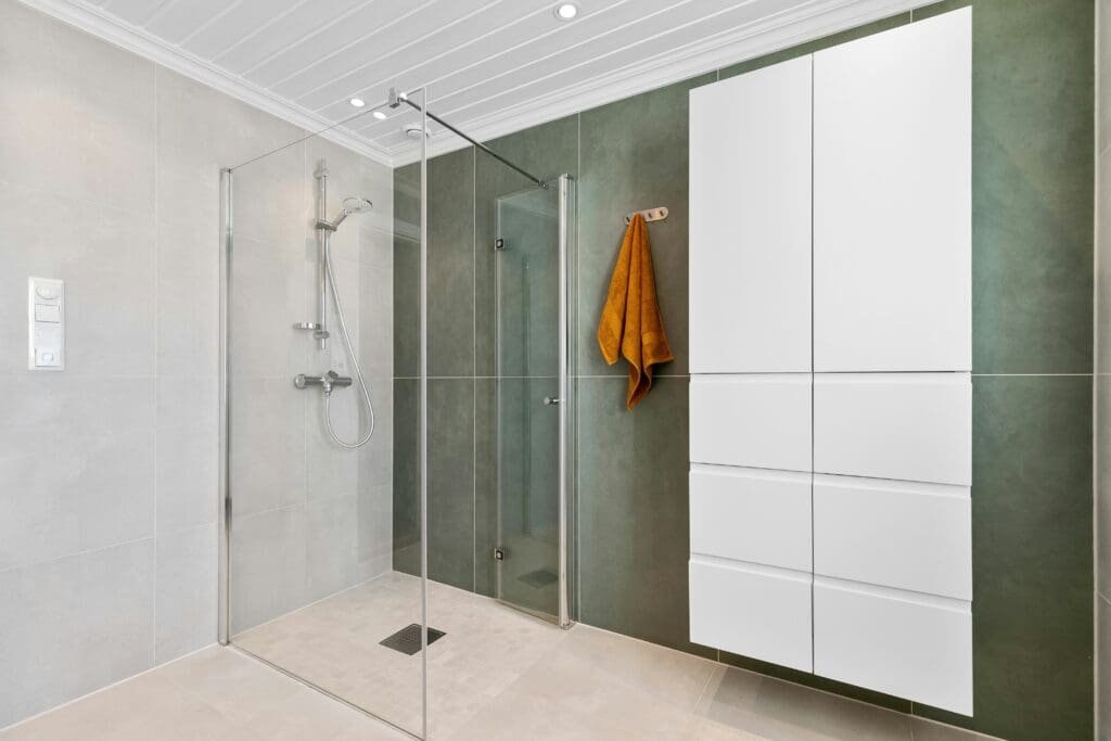 Low-threshold walk-in shower with glass doors, grab bars, and non-slip flooring for safety and accessibility