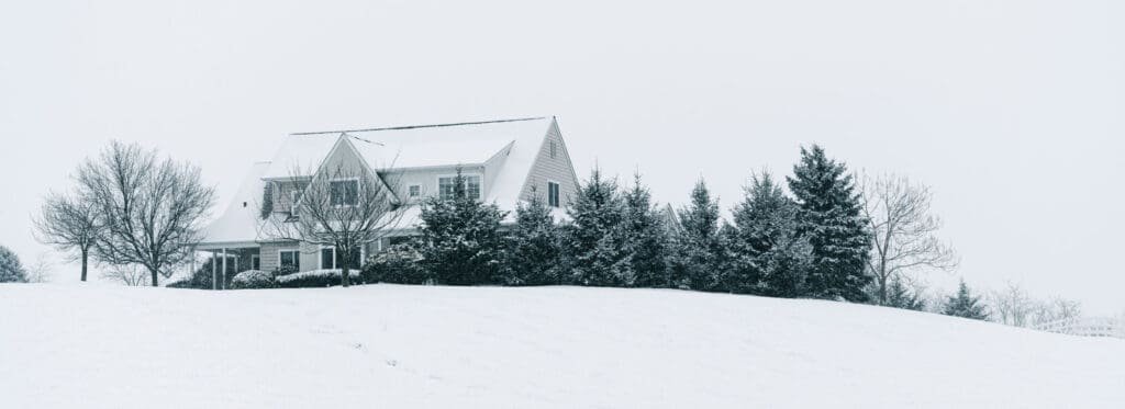 Winterize your house in Terre Haute with a snow-covered roof, clear gutters, and long downspout extensions