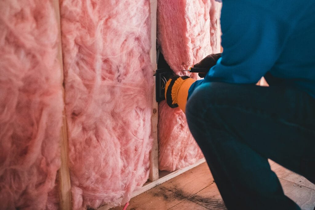 Installing fiberglass batt insulation in 2x4 wall cavities in a Terre Haute home