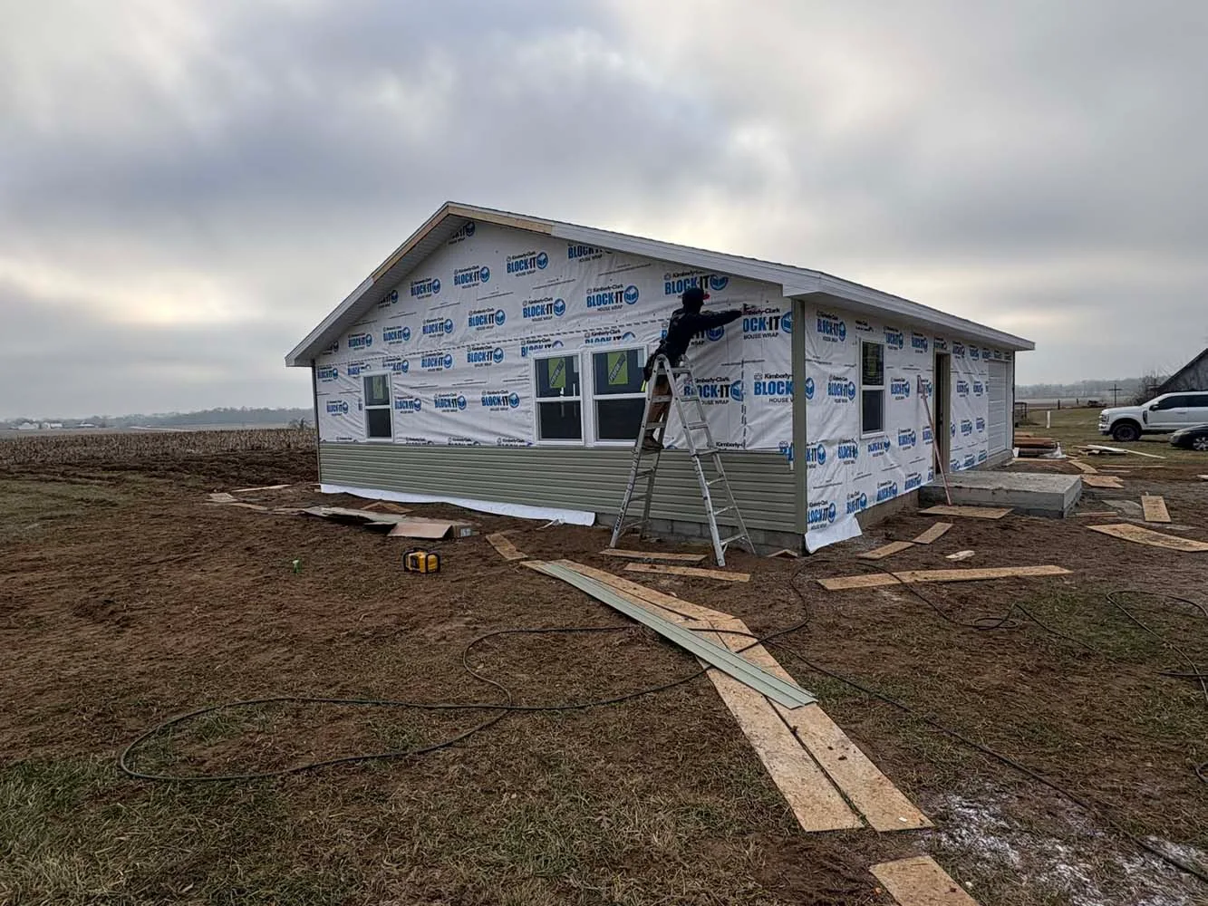 taping housewrap before siding a new home construction