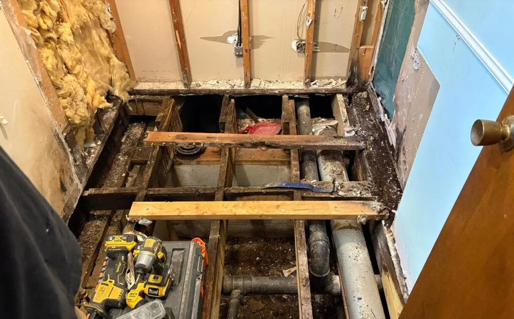 Leaking tile shower showing water damage near the base of the wall in a Terre Haute Indiana home