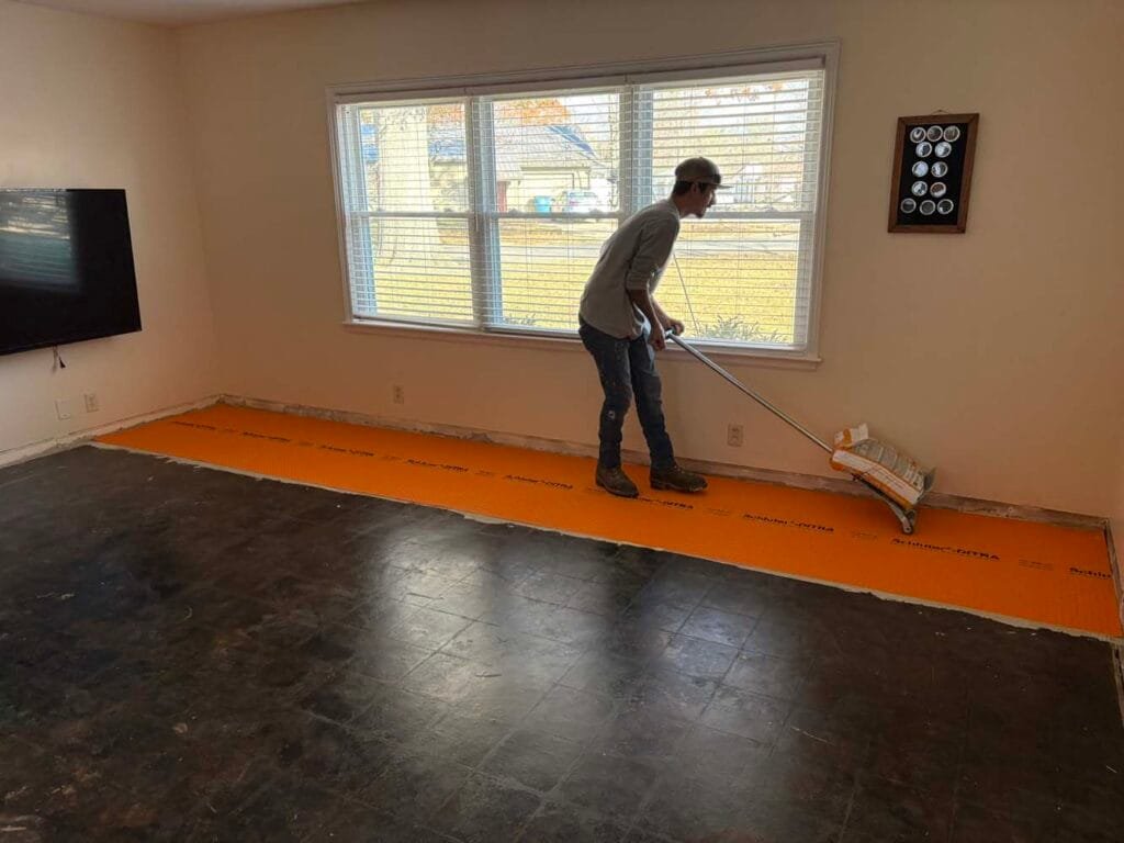 Installing Schluter Ditra with the roller to get maximum adhesion to the sub floor 